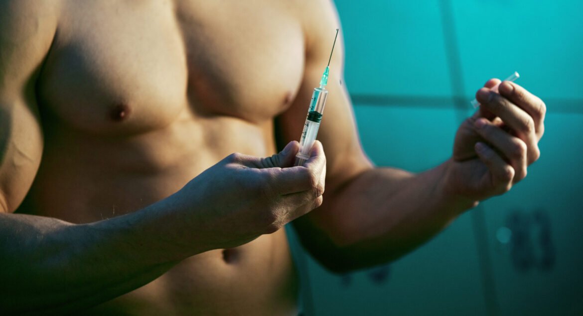 Close up of muscular athlete with injection of performance-enhancing drugs in locker room.