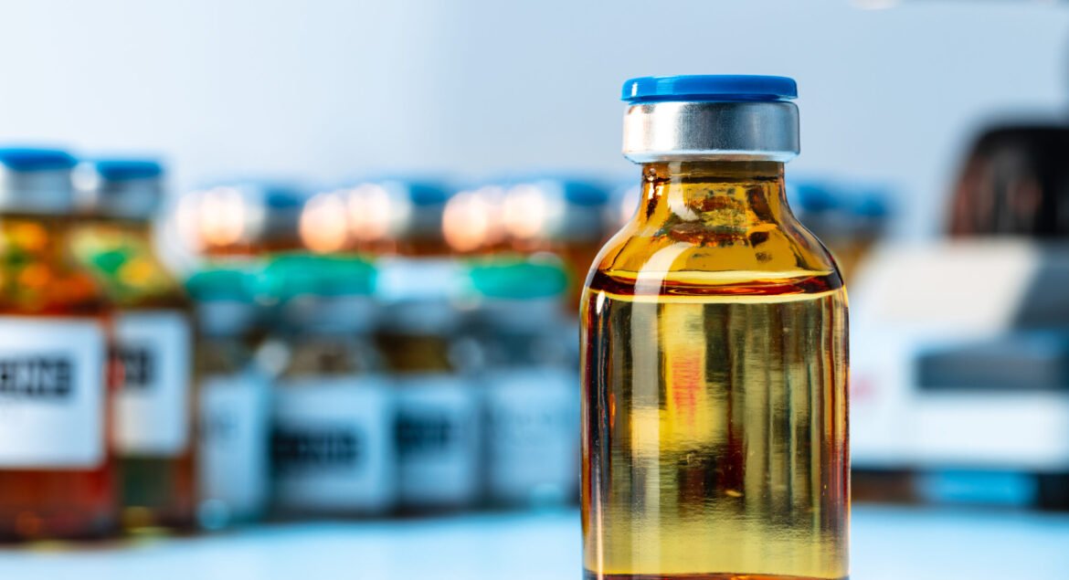 Medical vial with medication near microscope close up photo