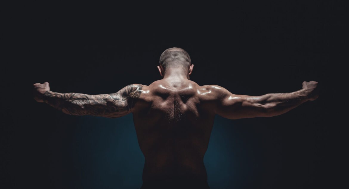 muscular male Bodybuilder posing in studio over black