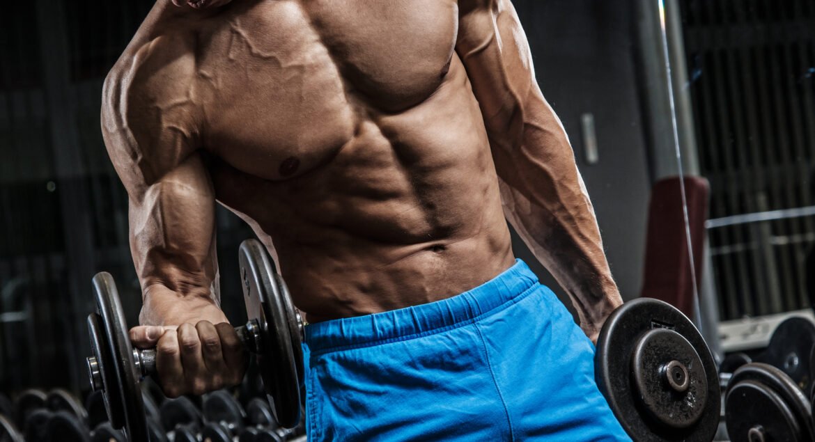 Young muscular man during workout in the gym