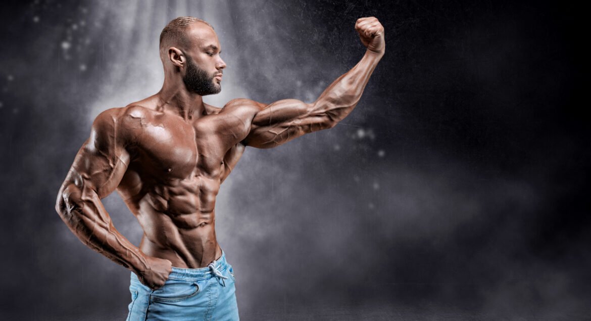 muscular-man-flexing-in-studio-with-gray-backgroun-2026-04-14-00-43-41-utc